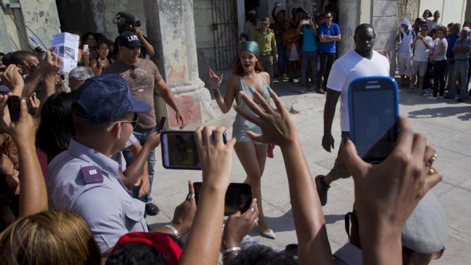 Pop artist Rihanna waves at fans as she leaves a building on the Malecon, after a photo shoot with photographer Annie Leibovitz, in Havana, Cuba, Friday, May 29, 2015. Cuban state media say Rihanna arrived in Cuba on Wednesday. The media reports say she also has recorded video footage in the capital