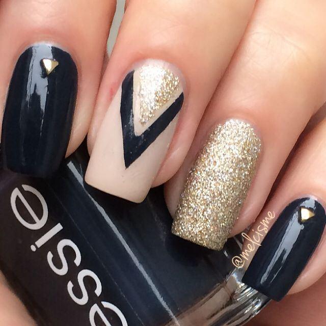 uñas largas pintadas de negro y dorado