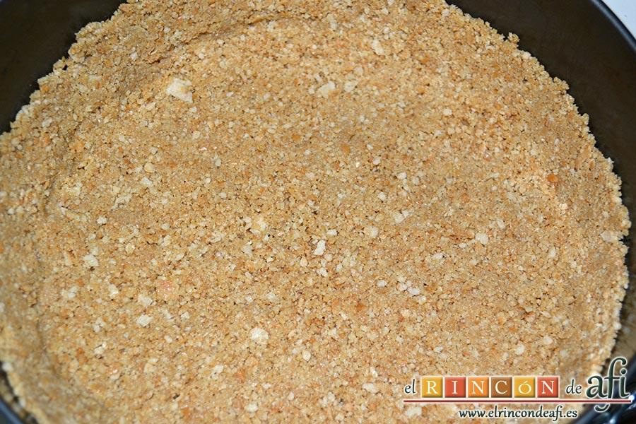 Tarta soufflé de limón con base de galletas, removemos bien hasta que se integre la galleta con la mantequilla. Colocamos una hoja de papel de horno en el fondo de un molde desmoldable y ponemos encima la mezcla de galleta haciéndole un borde con ayuda de los dedos