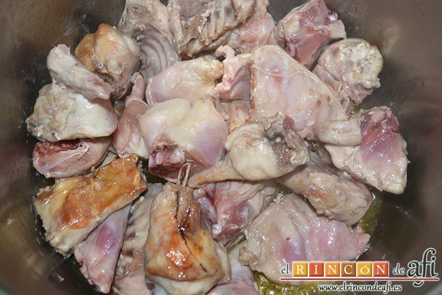 Conejo al ajillo, pedimos al carnicero que nos trocee el conejo y lo introducimos en una olla con un chorro de aceite de oliva