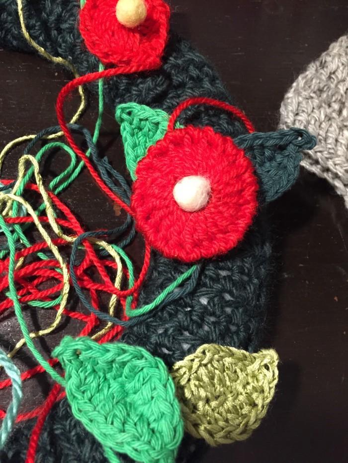 Lanas e hilos de diferentes tonos de verde, bolitas de bellón y cashmilon rojo para las flores.