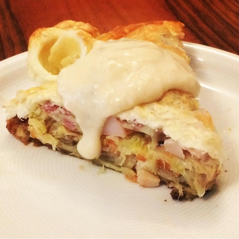Hermosa porción de tarta de verduras, bacon y queso gruyere