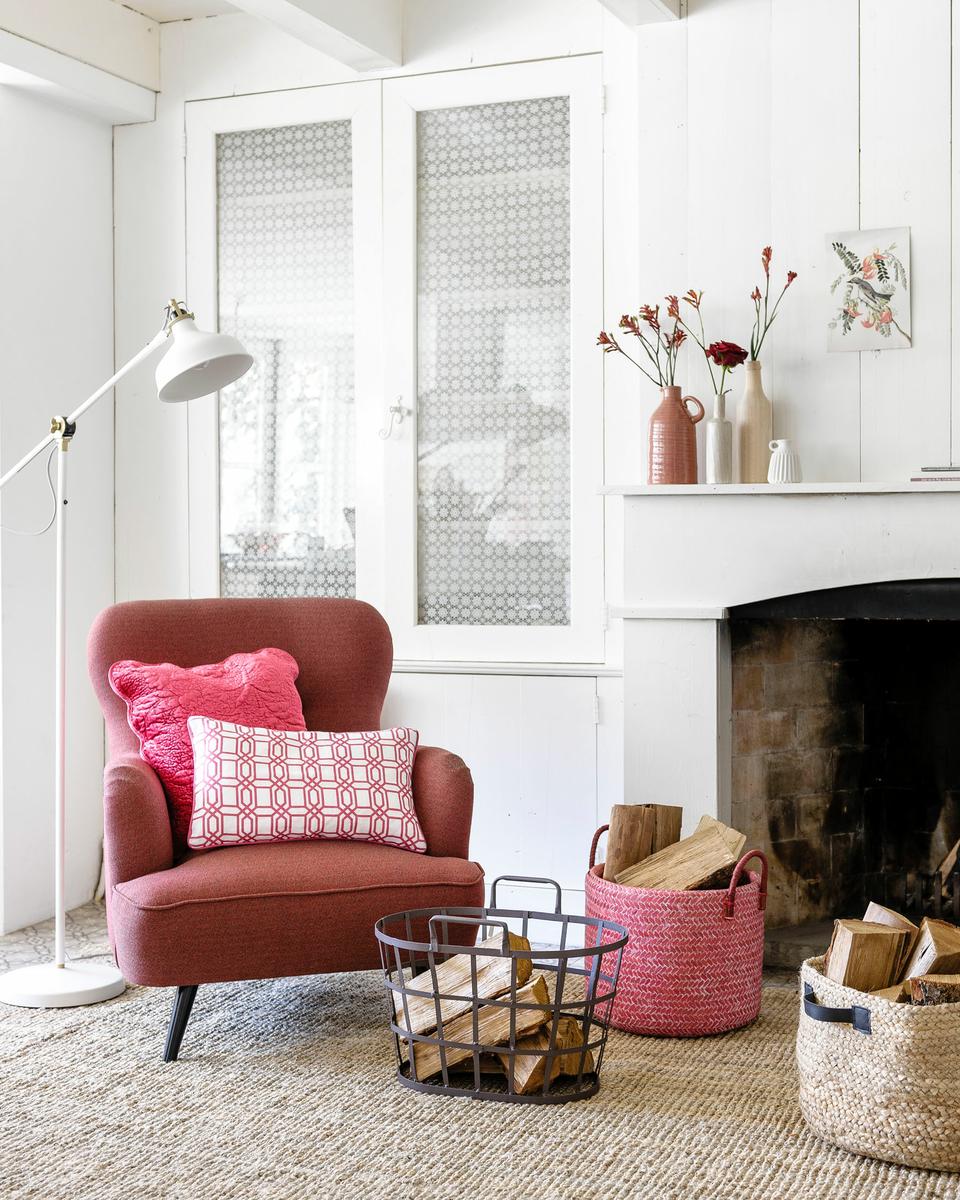 Rincón de relax en blanco con sillón y complementos en rojo