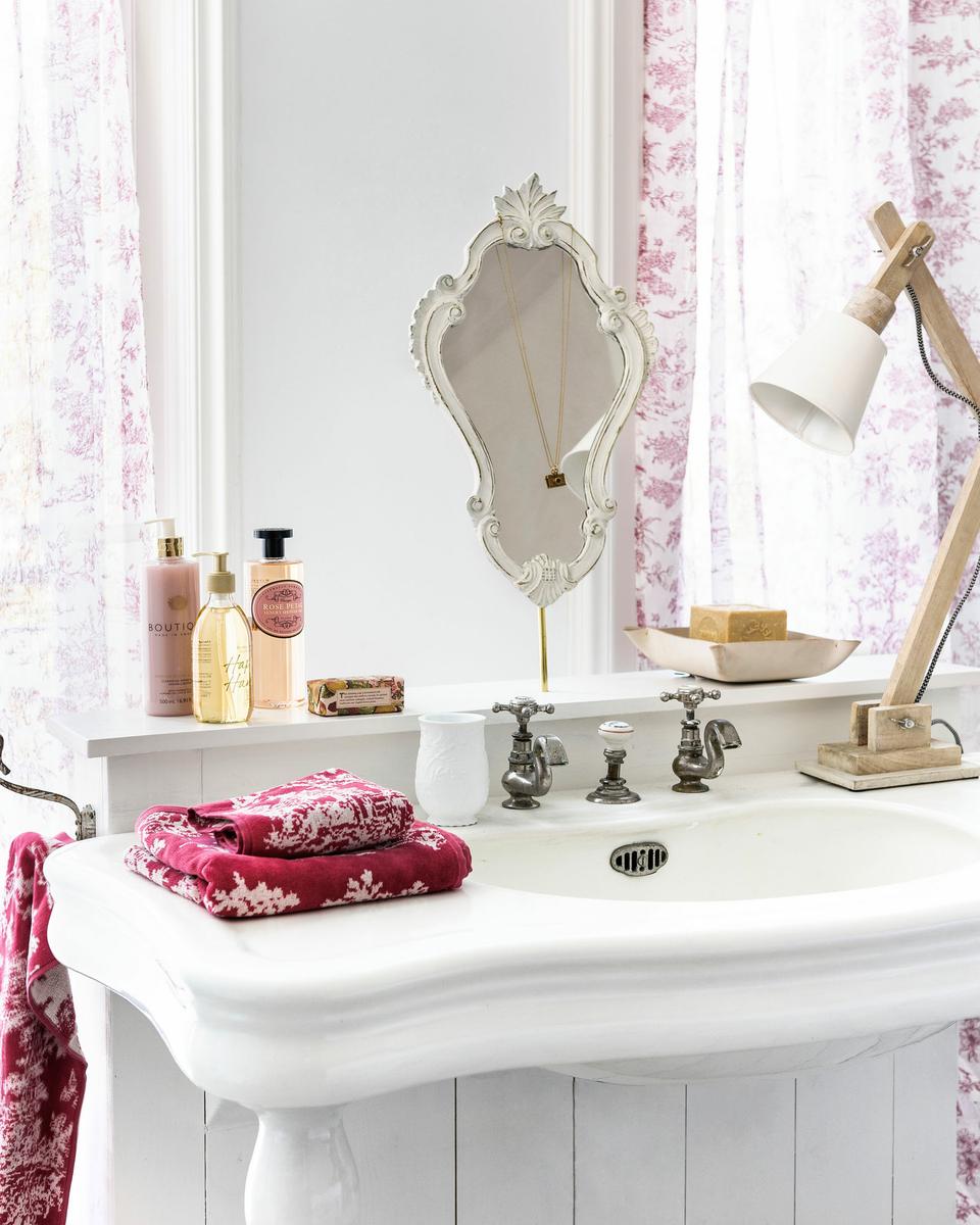 Detalle baño en blanco con complementos en rojo