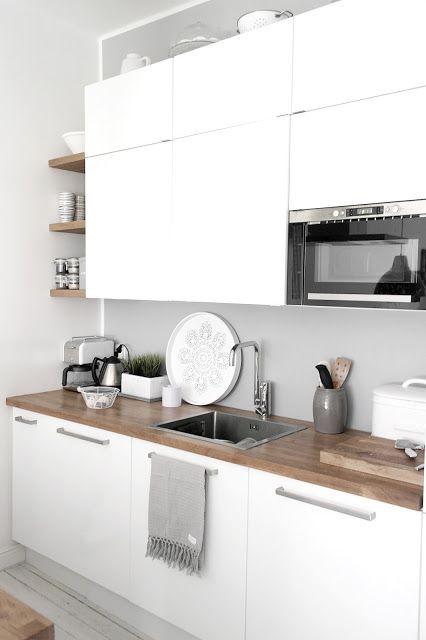 Cocina con muebles blancos y encimera de madera