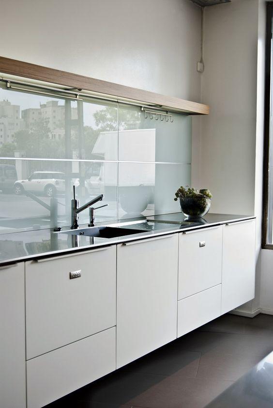 Cocina con muebles blancos y encimera de acero inoxidable