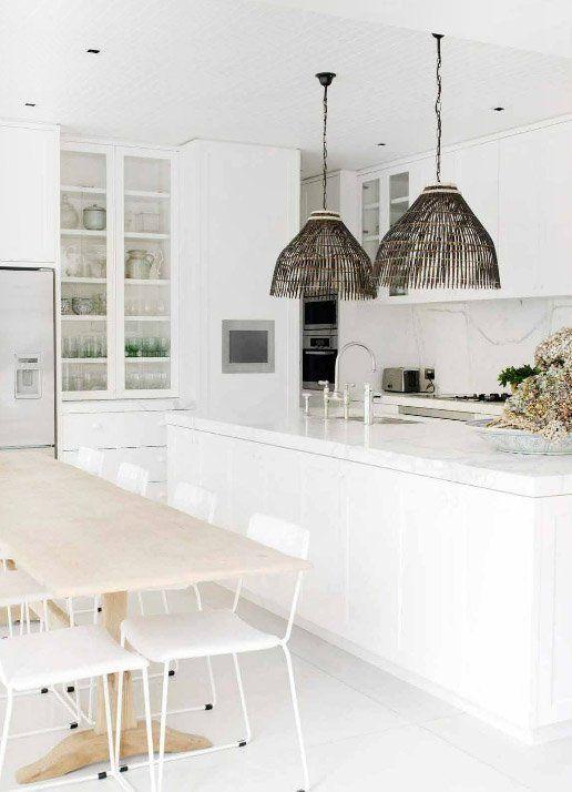 Cocina toda blanca con mesa auxiliar para la zona office