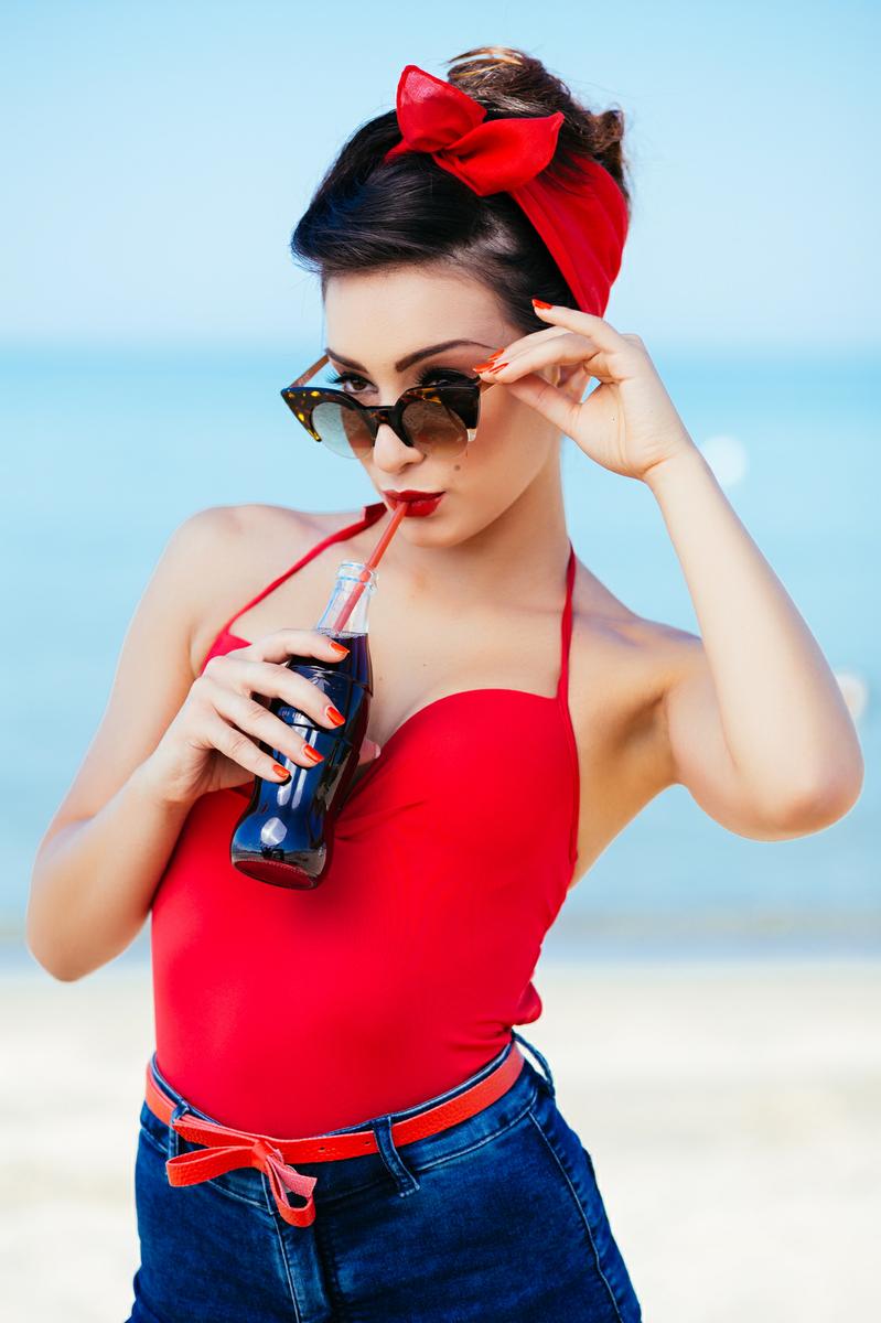Pin-up at sea drink and watch over sunglasses