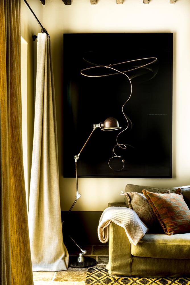 Detalle del sofá, lámpara de pie y cuadro de la villa en la Toscana