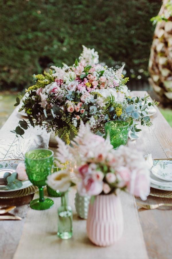 una mesa veraniega con verdes, rosas y dorados.