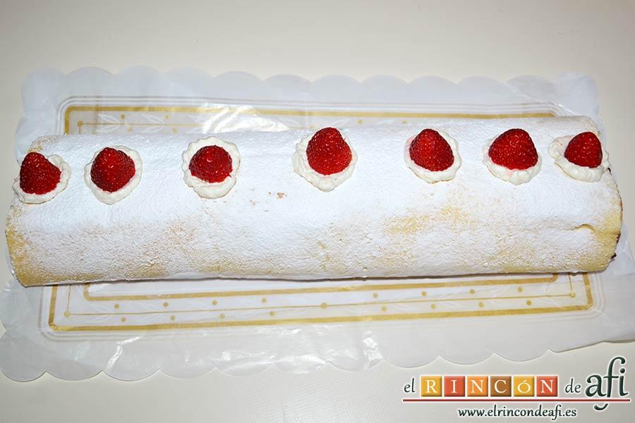 Brazo de gitano relleno de nata (crema de leche) y fresa, espolvorear con azúcar glass y decorar