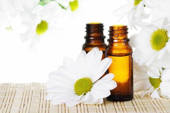 Bottles of Essential Oil with Flowers Close