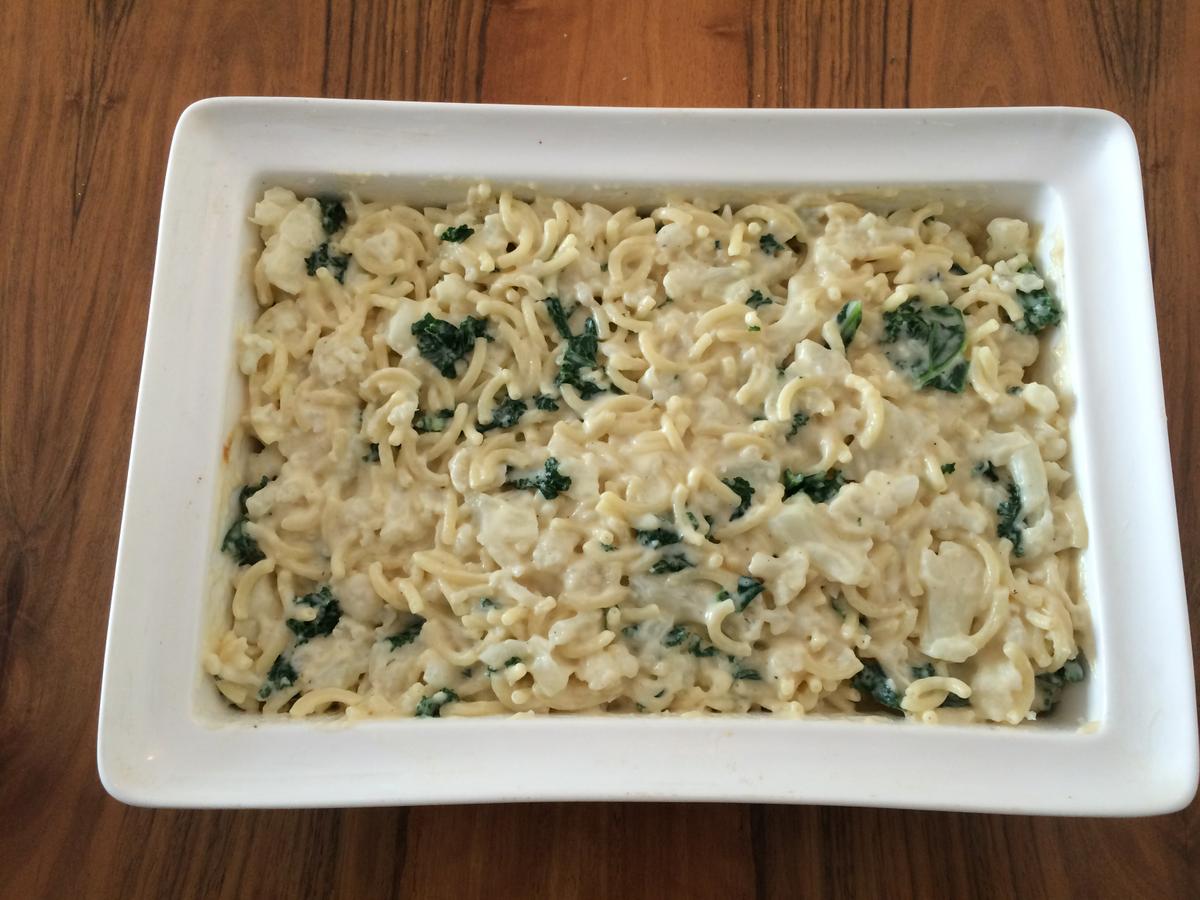 Mezclando la salsa de cheddar con los macarrones y las verduras