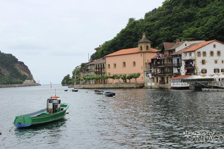 foto de pueblo marinero con barca en medio