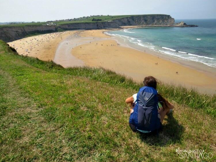 noelia sentada en una pradera verde mirando el mar