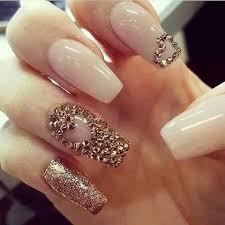 Uñas nude con diseño de corazón en tachuelas