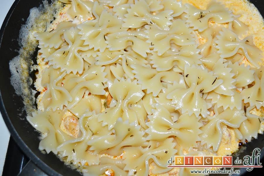 Farfalles con gambones y mejillones, escurrir la pasta y volcarla sobre la salsa