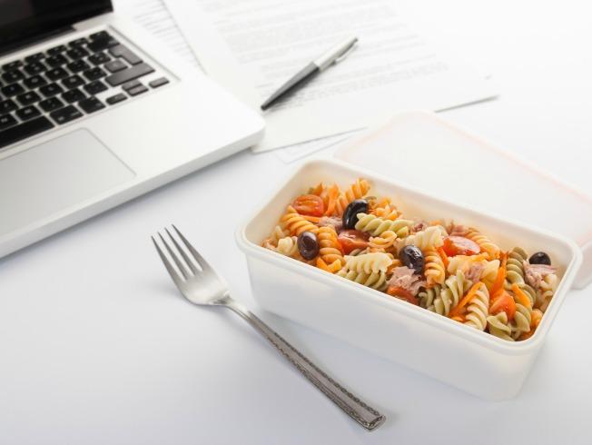 Eating a pasta salad with vegetables and tuna in the office