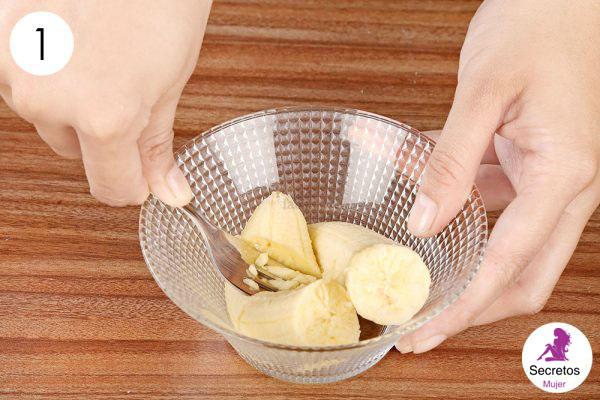 Triturar 2 plátanos en un tazón para hacer una mascarilla de bricolaje para la piel seca