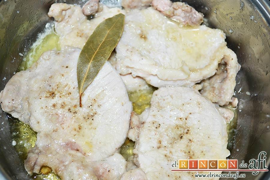 Chuletas de cerdo con alcaparras y anchoas, añadir el zumo de limón y una hoja de laurel