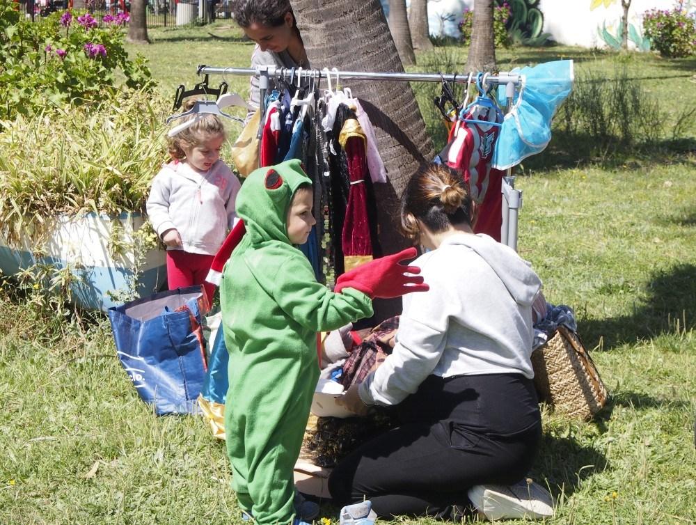 Niños eleigiendo disfraces del armario de disfraces exterior en el parque Princes Sofía