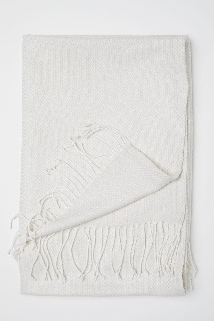 textiles en blanco que aporten luz al sofá gris