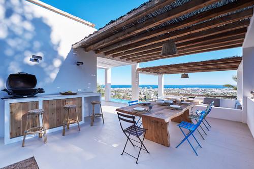 comedor en una terraza con chimenea y toques azules