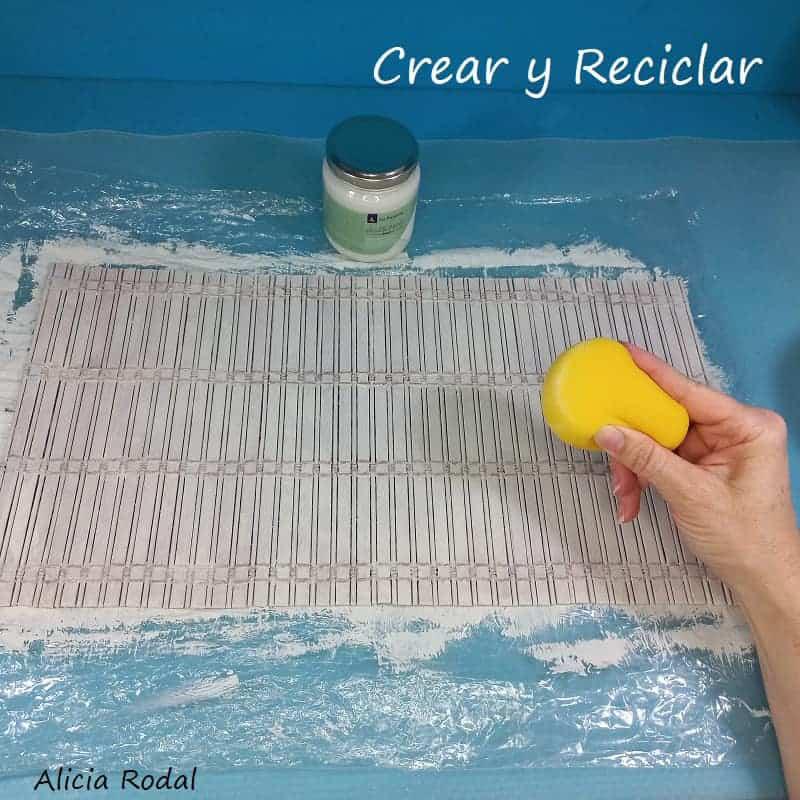 Como hacer hermosas manualidades para decorar tu casa y al mismo tiempo con varias funciones, tan solo con reciclaje. Con una lata grande de galletas o caramelos con su tapa, 2 manteles individuales de madera o bambú y la tela de yute de un saco de patatas, vamos a hacer una bella decoración para el salón, la cocina o el baño. DIY