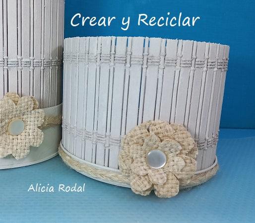 Como hacer hermosas manualidades para decorar tu casa y al mismo tiempo con varias funciones, tan solo con reciclaje. Con una lata grande de galletas o caramelos con su tapa, 2 manteles individuales de madera o bambú y la tela de yute de un saco de patatas, vamos a hacer una bella decoración para el salón, la cocina o el baño. DIY