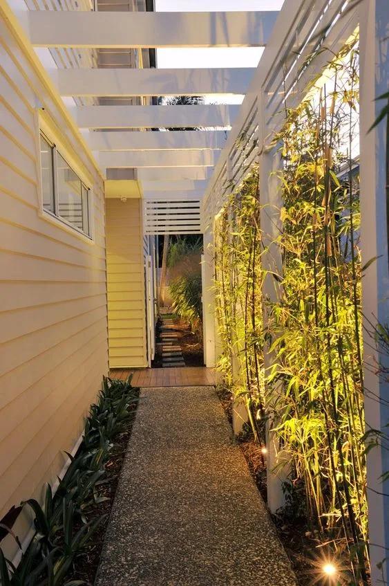 Iluminación para un jardín lateral pegado al cerco de una casa