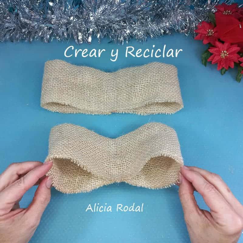 En este tutorial te muestro cómo con unos simples materiales reciclados, podemos hacer una bella decoración navideña para colgar en la pared o en la puerta de entrada de tu hogar y sustituir a la tradicional corona de adviento.