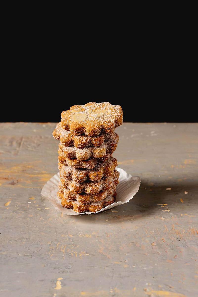 En una mesa de madera están puestos los mantecados manchegos formando una torre.