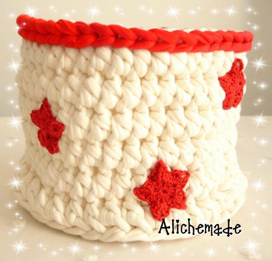 Cesto de trapillo blanco y borde rojo, con estrellas de ganchillo rojas.