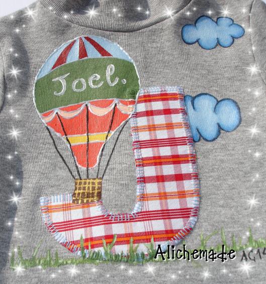 Detalle de la camiseta con inicial aplicada, para Joel, y globo aerostático pintado a mano.