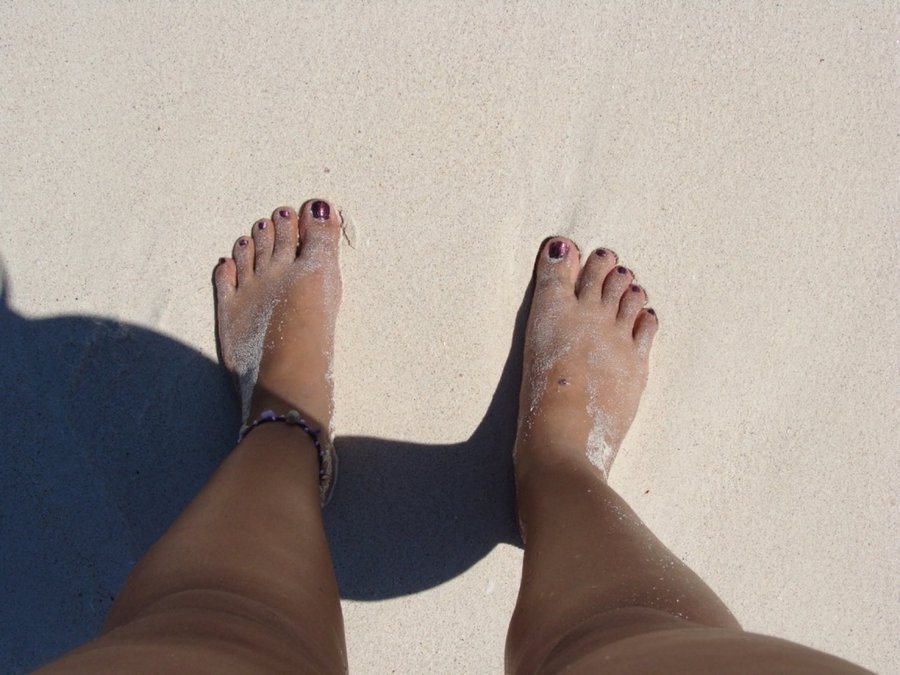 mar arena y pies en tulum
