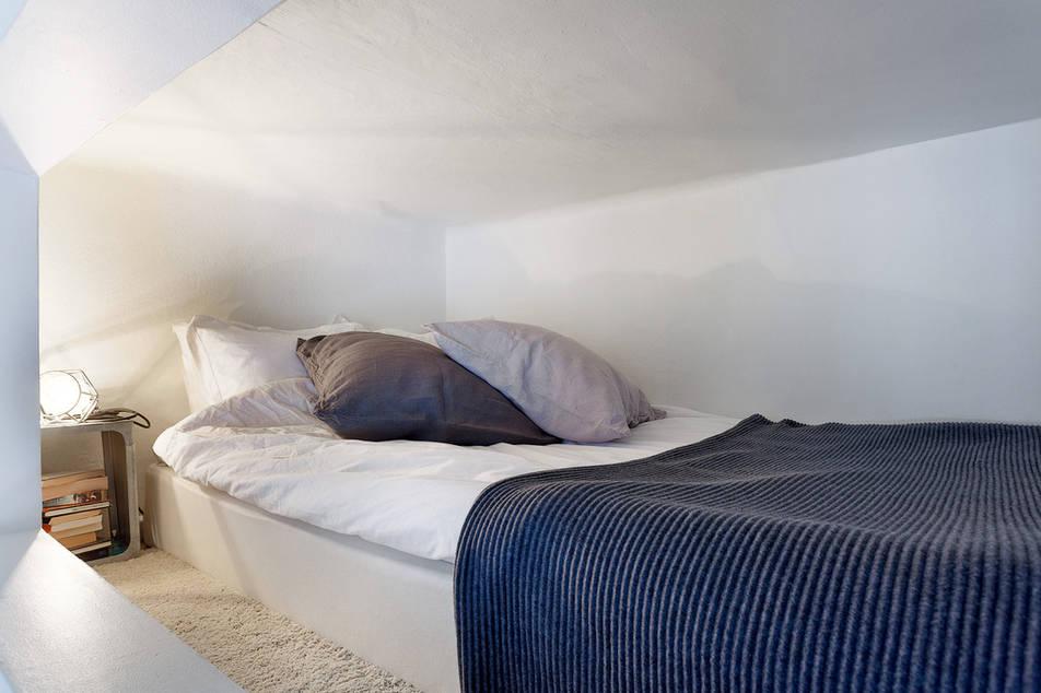 Un apartamento con la cama en un altillo.