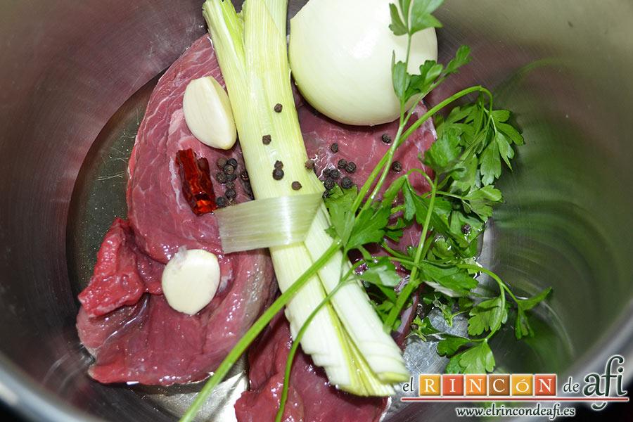 Frittata de morcillo y pimientos, en una olla exprés ponemos un chorro de aceite de oliva, el morcillo, un trozo de pimienta picante, los granos de pimienta negra, 1 cebolla, los 2 dientes de ajo, unas ramitas de perejil fresco y la parte verde de 1 puerro