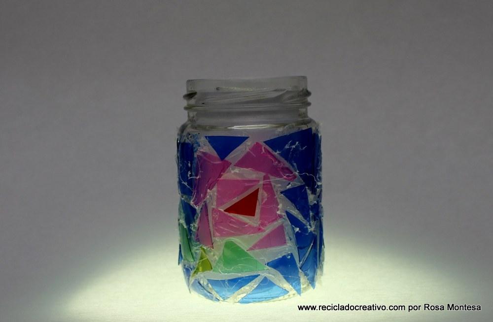 Trencadís reciclando botellas de plástico en un bote de cristal