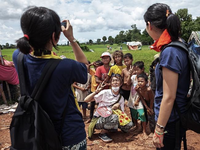 A tourist poses with children that work in the dump. Picture: David Rengel / AnHua
