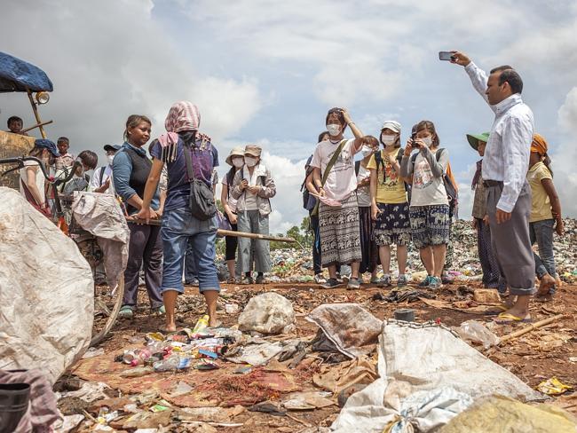 A woman who is working in the landfill demonstrates the use of the hook to tourists. Pict