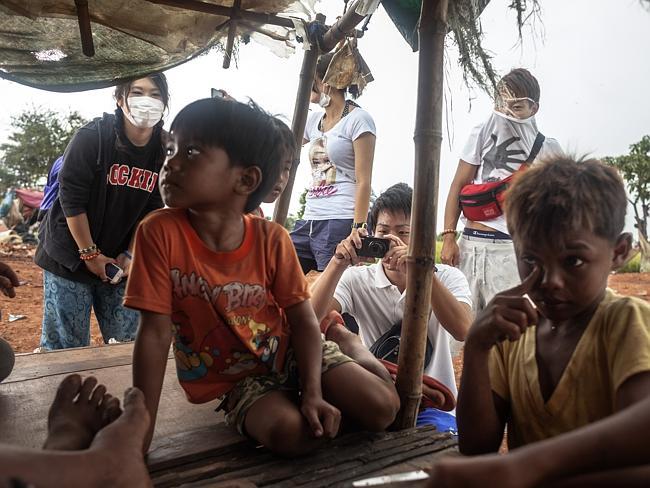 A group of tourists take photos of local children while they?re resting. Picture: David R