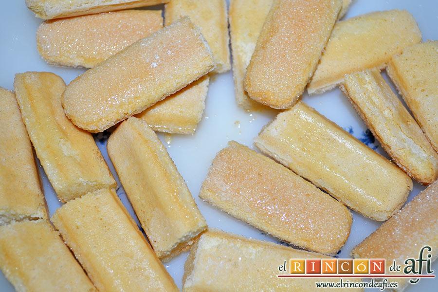 Tiramisú de mango, colocar el zumo de naranja en un plato e ir añadiendo los bizcochos cortados en dos para empaparlos