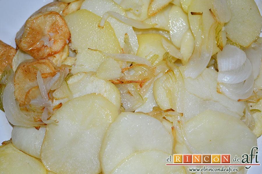 Bacalao gratinado con base de tomate, cortamos las papas peladas en rodajas y las cebollas en aros y las freímos con una pizca de sal en abundante aceite de oliva