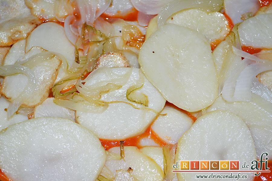 Bacalao gratinado con base de tomate, ponemos encima una capa de papas y cebolla