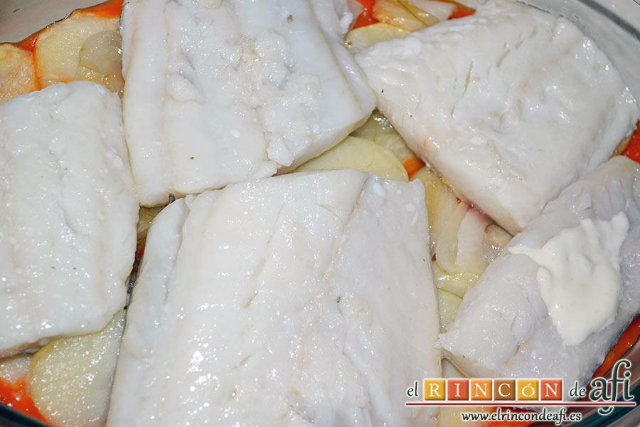 Bacalao gratinado con base de tomate, colocamos encima los lomos de bacalao con la piel hacia abajo