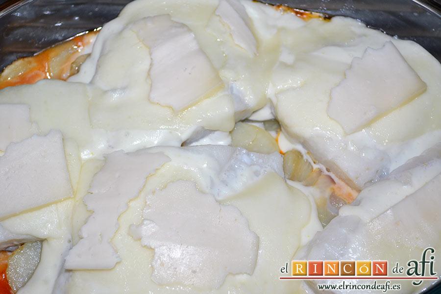 Bacalao gratinado con base de tomate, añadimos la mayonesa sobre los lomos de bacalao para terminar con las lonchas de queso