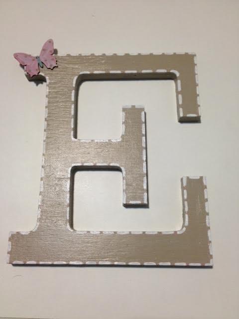 Letra de madera decorada con silueta de mariposa