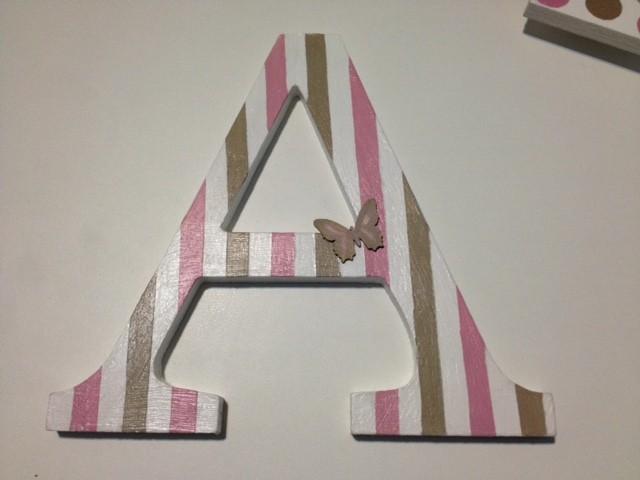 Letra de madera A, decorada con rayas en pintura acrílica