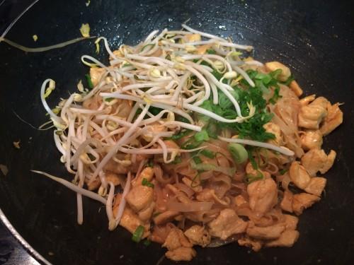 Añadiendo las cebolletas verdes y los brotes de soja