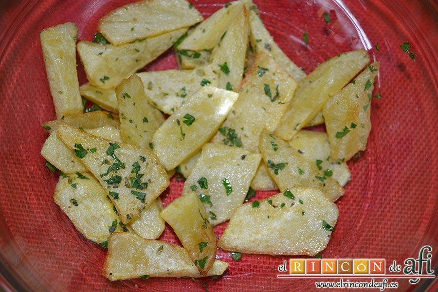 Cochifrito con papas brutas, cuando estén las papas bien fritas las ponemos en un bol y les añadimos la mezcla de las especias, sal y removemos bien